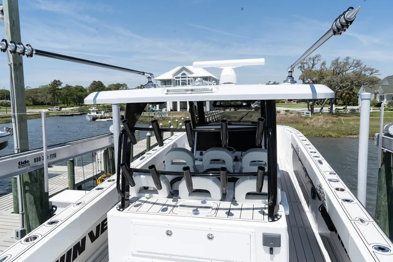 Slide: The Image of 2025 Twin Vee 400 GFX2 CC boat docked, showcasing seating and helm area. - 45