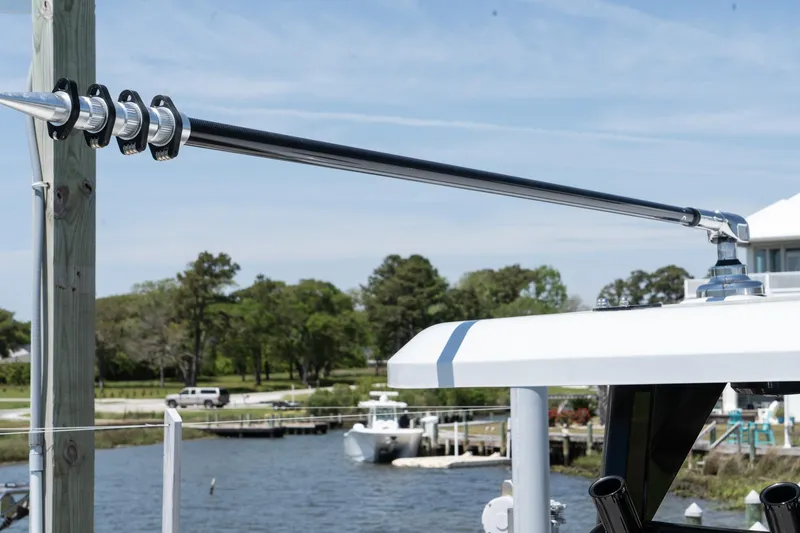 Slide: The Image of Outrigger on 2025 Twin Vee 400 GFX2 CC boat docked by a scenic waterfront. - 46