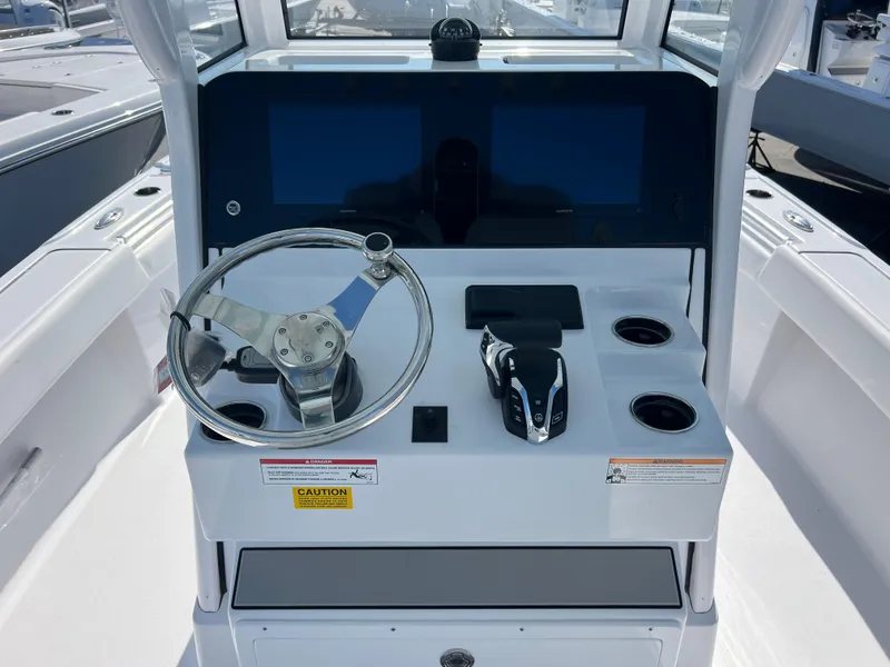 Slide: The Image of 2025 Sportsman Masters 267OE Bay Boat helm with steering wheel and dual screens. - 11