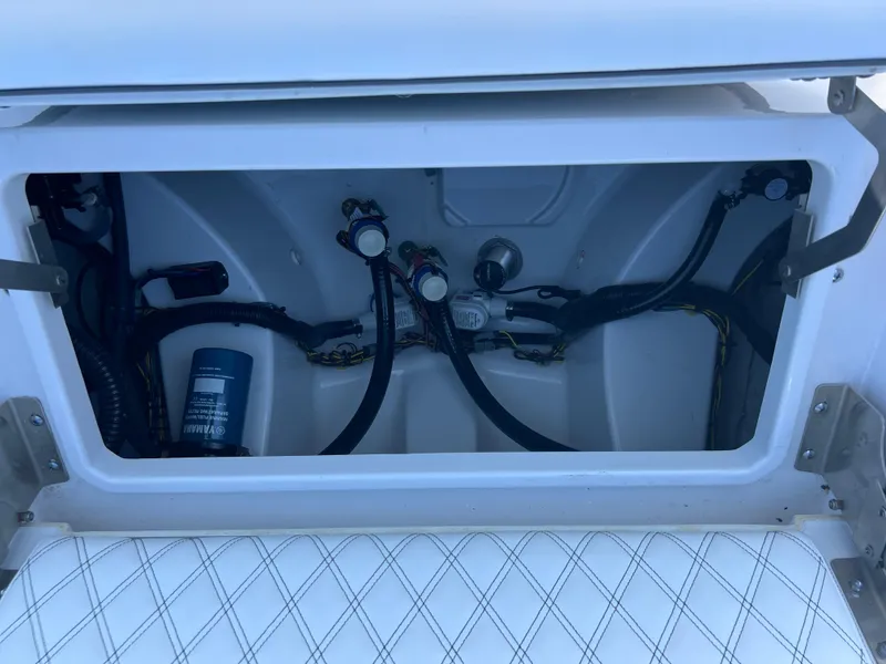 Slide: The Image of Storage compartment of 2025 Sportsman Masters 267OE Bay Boat, showing wiring and components. - 19