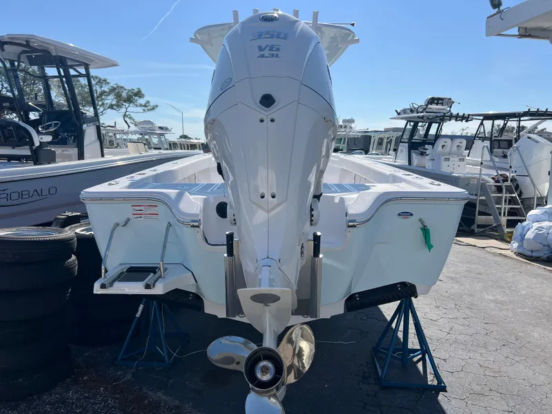 Slide: The Image of 2025 Sportsman Masters 267OE Bay Boat with powerful outboard engine, displayed on stands. - 5