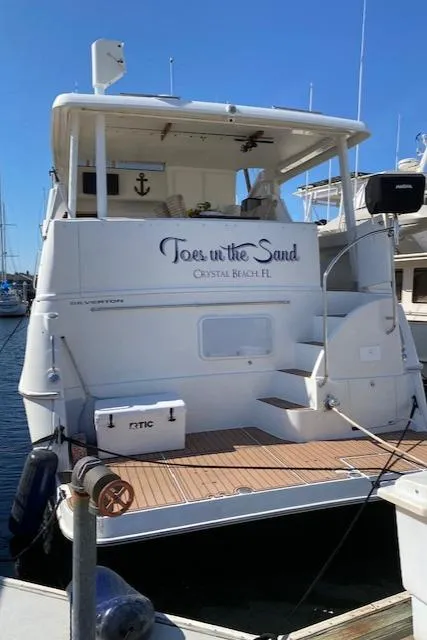 Slide: The Image of 2002 Silverton 453 Motor Yacht docked, featuring "Toes in the Sand" on the stern. - 12