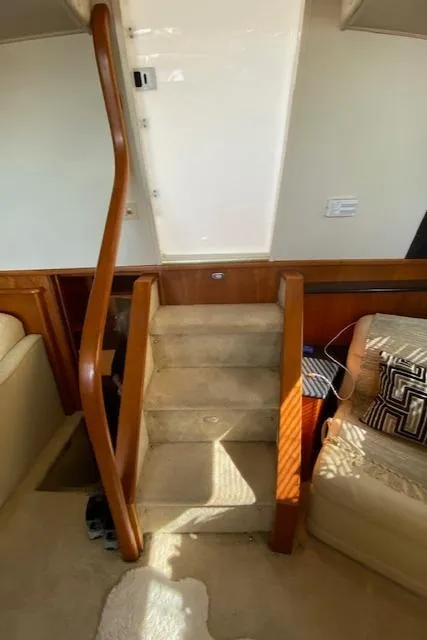 Slide: The Image of Interior stairs of 2002 Silverton 453 Motor Yacht with beige carpet and wooden railings. - 17