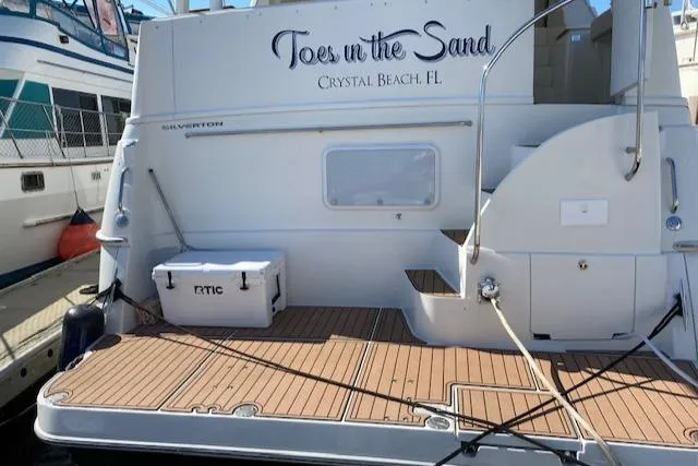 Slide: The Image of 2002 Silverton 453 Motor Yacht docked, featuring "Toes in the Sand" text, Crystal Beach, FL. - 2