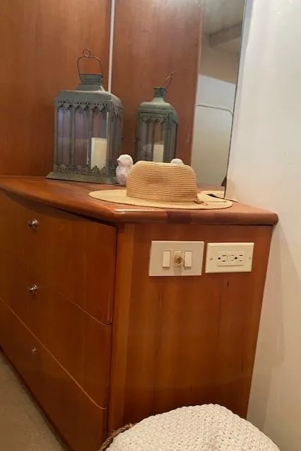Slide: The Image of 2002 Silverton 453 Motor Yacht interior with wooden dresser, lanterns, and a straw hat. - 23