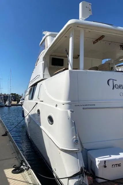 Slide: The Image of 2002 Silverton 453 Motor Yacht docked at marina under clear blue sky. - 3