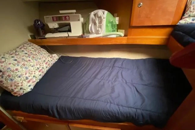Slide: The Image of 2002 Silverton 453 Motor Yacht cabin with bed, sewing machine, and fan. - 39