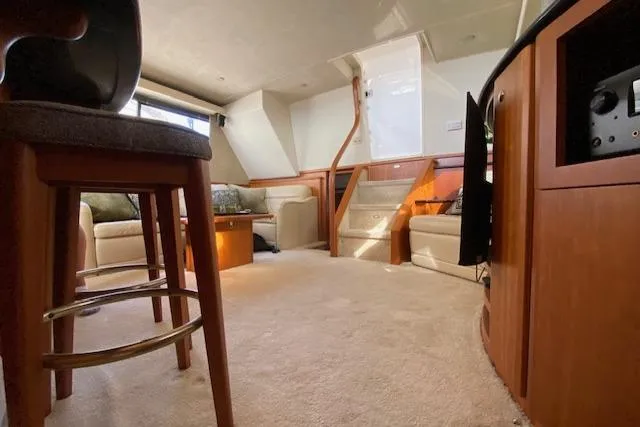 Slide: The Image of Interior of 2002 Silverton 453 Motor Yacht, featuring cozy seating and wooden accents. - 42