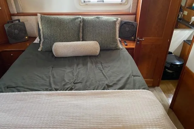 Slide: The Image of Interior of 2002 Silverton 453 Motor Yacht bedroom with cozy bedding and wooden accents. - 44