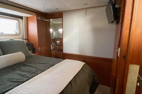 Slide: The Image of Interior of 2002 Silverton 453 Motor Yacht bedroom with bed, window, and TV. - 46