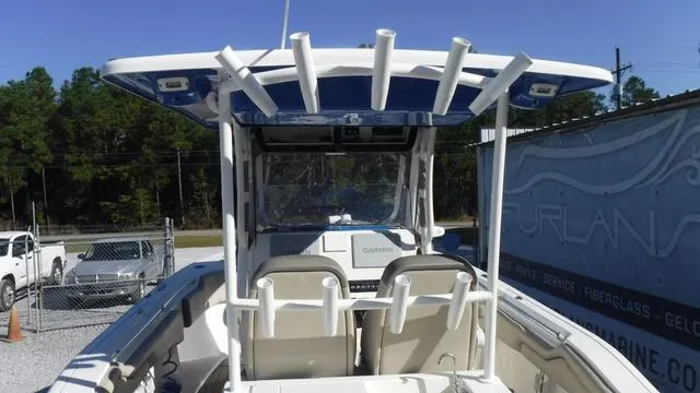 Slide: The Image of 2021 Key West 263FS boat with T-top and rod holders, parked outdoors. - 24