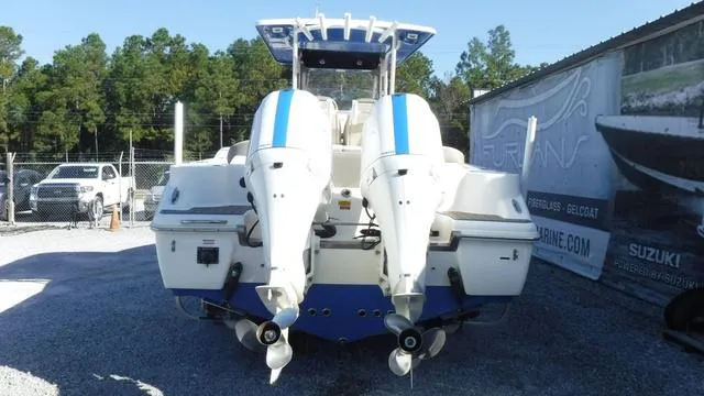 Slide: The Image of 2021 Key West 263FS boat with dual outboard engines, parked on gravel. - 4