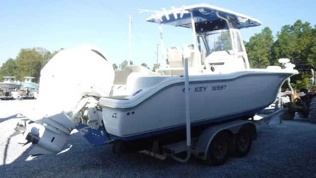 Slide: The Image of 2021 Key West 263FS boat on trailer, featuring dual engines and a T-top. - 5