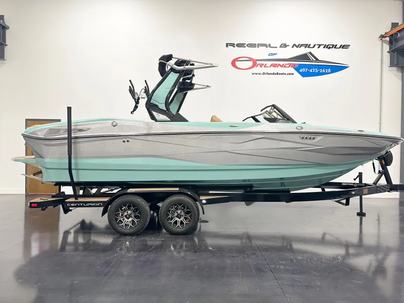 The Image of 2025 Centurion NV233 boat on trailer in showroom, side view. - 1
