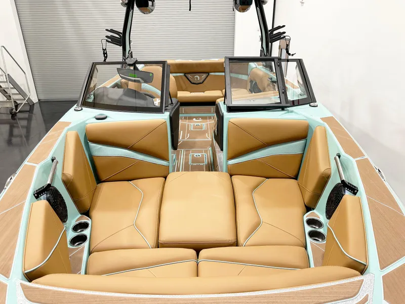 Slide: The Image of 2025 Centurion NV233 boat interior with tan and teal seating, cup holders, and sleek design. - 7