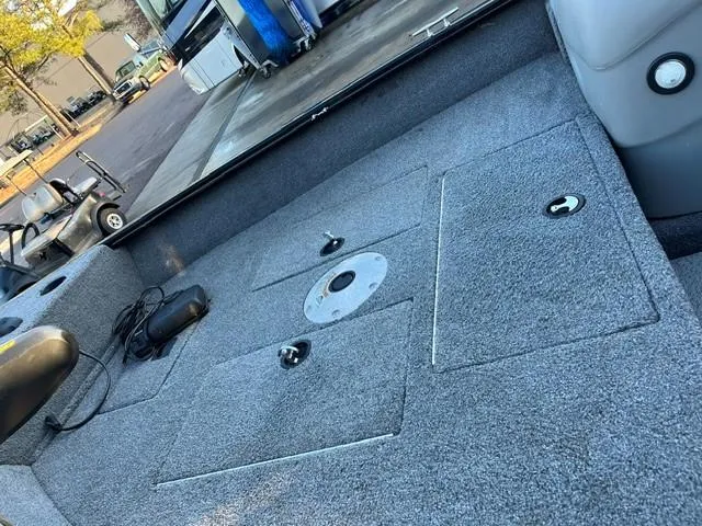 Slide: The Image of 2018 Tracker Pro Guide V-16 SC boat interior with carpeted deck and storage compartments. - 4