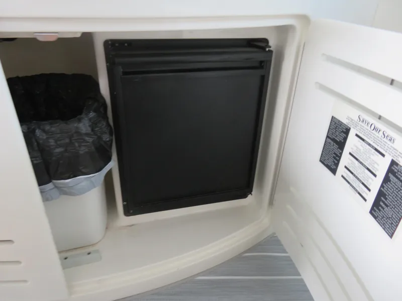Slide: The Image of 2001 Sea Ray 510DA interior storage with trash bin and black panel. - 9