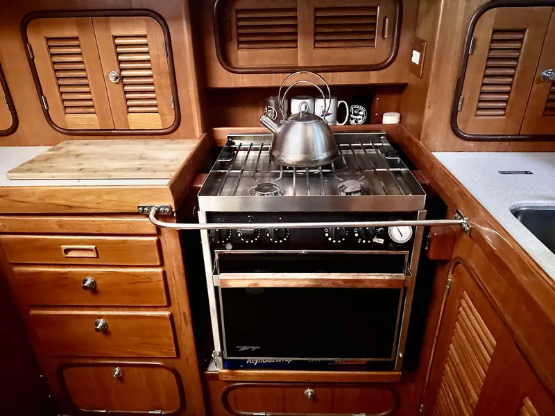 Slide: The Image of Wooden yacht kitchen with stove, kettle, and cabinets in a 1999 Passport Royal 43. - 17