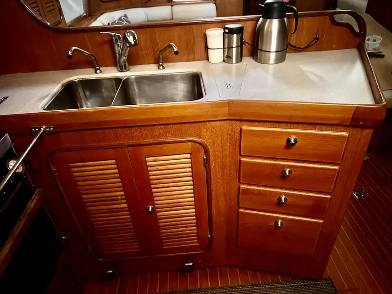 Slide: The Image of Wooden yacht kitchen with double sink, cabinets, and countertop appliances on a Passport Royal 43, 1999. - 18
