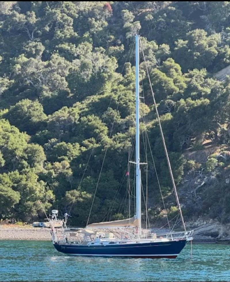 Slide: The Image of Sailboat "Passport Royal 43" anchored near lush green hillside, 1999 model. - 3