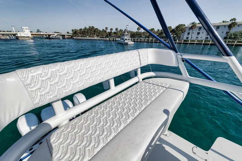 Slide: The Image of 2020 Yellowfin 42 Offshore boat with white seating, docked near palm trees and buildings. - 34