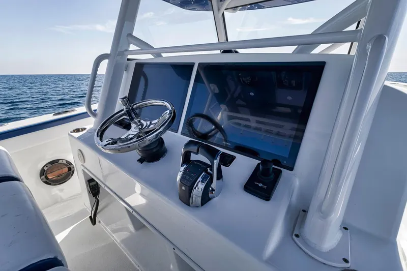 Slide: The Image of 2020 Yellowfin 42 Offshore boat dashboard with steering wheel and controls, ocean in background. - 41