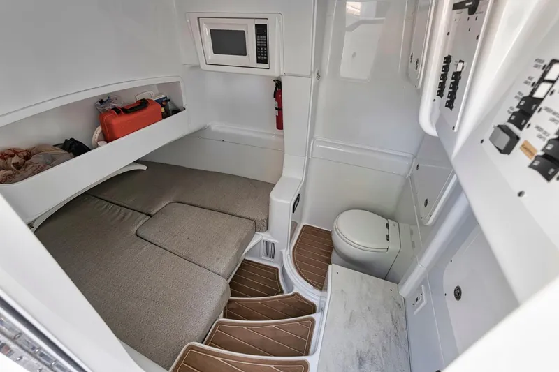 Slide: The Image of 2020 Yellowfin 42 Offshore cabin interior with bed, microwave, and toilet. - 47
