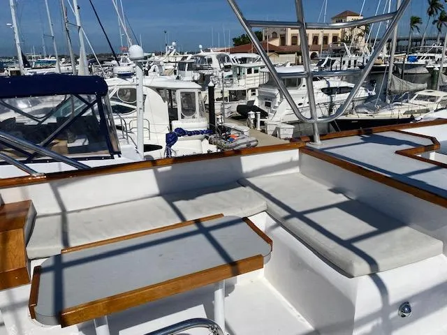 Slide: The Image of 1971 Matthews Motor Yacht with white seating, docked in a marina with multiple boats. - 13