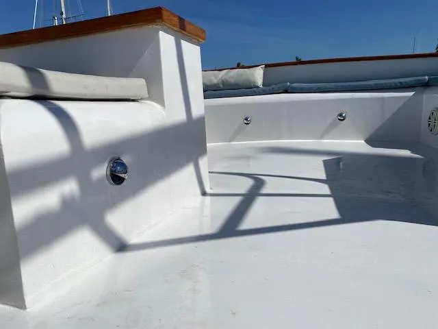 Slide: The Image of 1971 Matthews Motor Yacht deck with white finish and wooden accents under clear blue sky. - 14