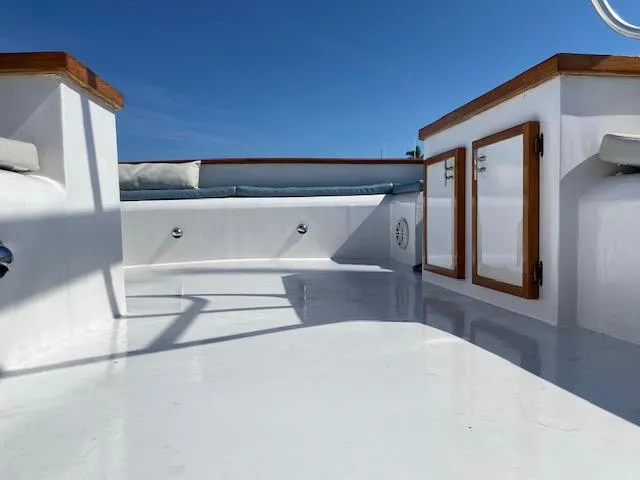 Slide: The Image of 1971 Matthews Motor Yacht deck with wooden accents under clear blue sky. - 15