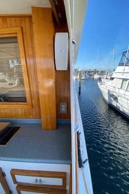 Slide: The Image of 1971 Matthews Motor Yacht deck with wooden paneling and marina view. - 25