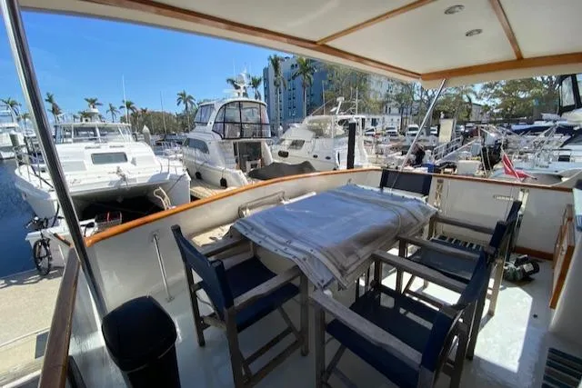 Slide: The Image of 1971 Matthews Motor Yacht with outdoor dining area, docked at a marina with other boats. - 26