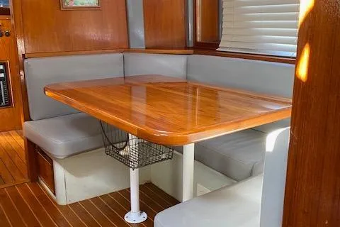 Slide: The Image of 1971 Matthews Motor Yacht interior with wooden dining table and cushioned seating. - 30