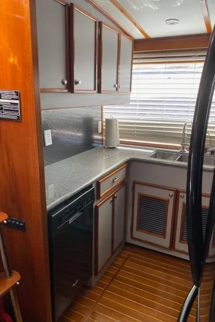 Slide: The Image of 1971 Matthews Motor Yacht kitchen with wooden cabinets, modern appliances, and sleek countertops. - 32