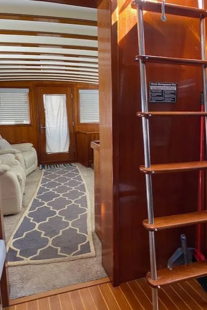 Slide: The Image of Interior of a 1971 Matthews Motor Yacht with wooden finishes and a cozy seating area. - 33