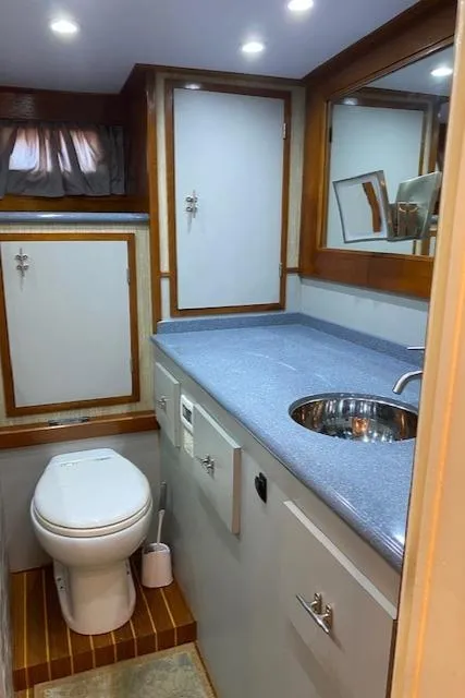 Slide: The Image of 1971 Matthews Motor Yacht bathroom with modern fixtures, wood accents, and a sleek countertop. - 39