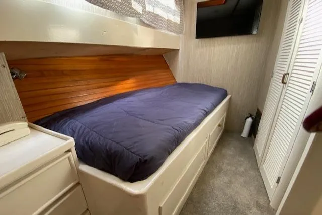 Slide: The Image of 1971 Matthews Motor Yacht cabin with single bed, wood paneling, and storage drawers. - 44