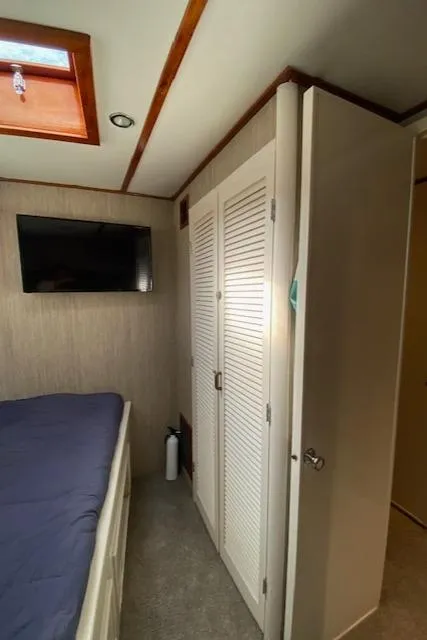 Slide: The Image of 1971 Matthews Motor Yacht interior with bed, closet, and wall-mounted TV. - 45