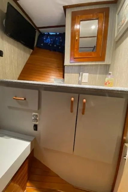 Slide: The Image of Interior of a 1971 Matthews Motor Yacht with wooden cabinetry and modern amenities. - 47