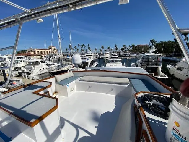 Slide: The Image of 1971 Matthews Motor Yacht docked in a marina, surrounded by other boats and palm trees. - 7