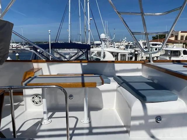 Slide: The Image of 1971 Matthews Motor Yacht deck with seating and table, docked at a marina. - 9