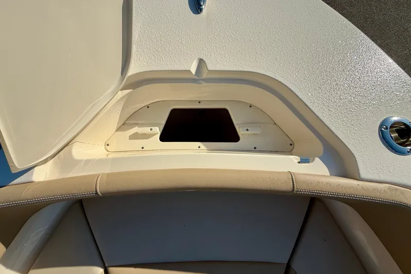 Slide: The Image of 2025 Scout 215 XSF boat storage compartment with open hatch and cushioned seating. - 17