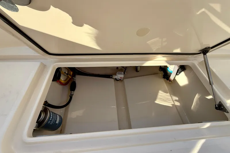 Slide: The Image of Open storage compartment in 2025 Scout 215 XSF boat, showing internal components. - 19