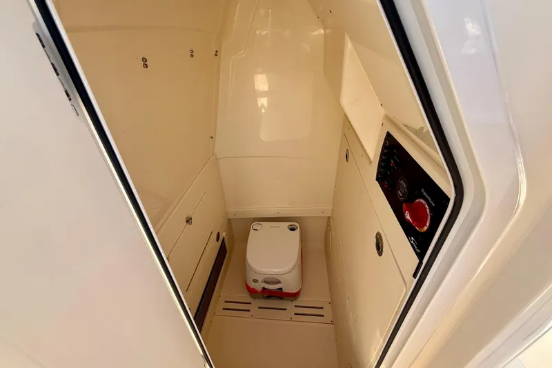 Slide: The Image of 2025 Scout 215 XSF boat interior with compact toilet and control panel. - 21