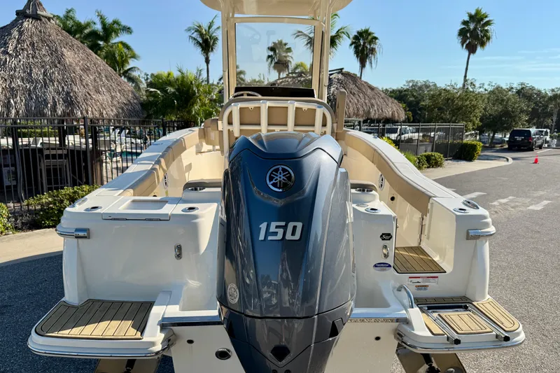 Slide: The Image of 2025 Scout 215 XSF boat with Yamaha 150 engine, parked near tropical palm trees. - 3