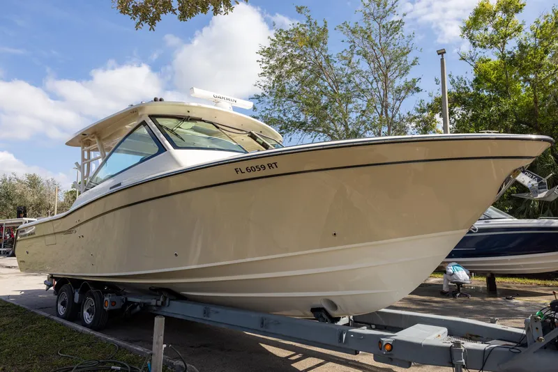 Slide: The Image of 2019 Grady-White Freedom 375 boat on trailer, parked outdoors under a clear sky. - 2