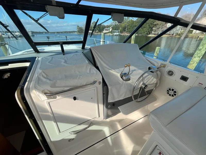 Slide: The Image of 2001 Tiara Yachts 4100 Open helm with covered controls, overlooking serene waterfront. - 14