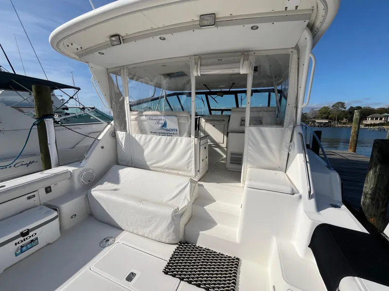 Slide: The Image of 2001 Tiara Yachts 4100 Open, spacious deck, white seating, docked at marina. - 2