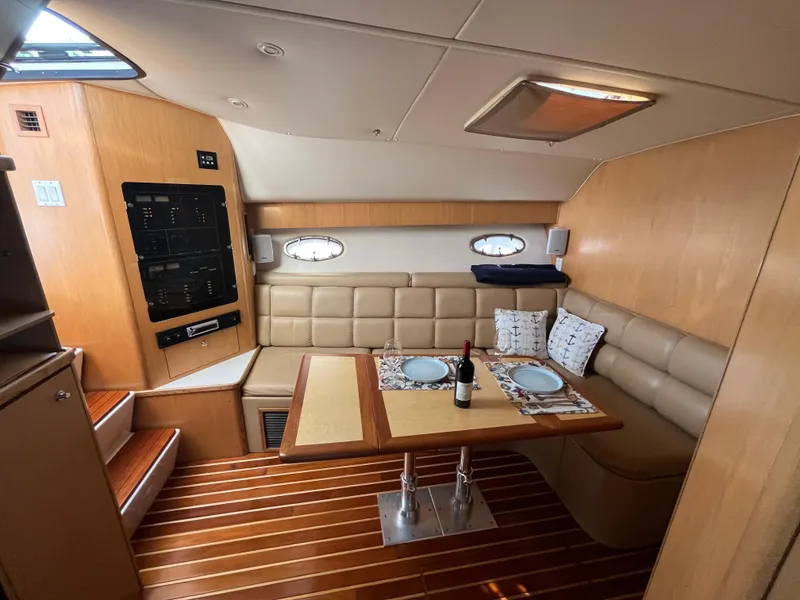Slide: The Image of Interior of 2001 Tiara Yachts 4100 Open, featuring a cozy dining area with wood flooring. - 24