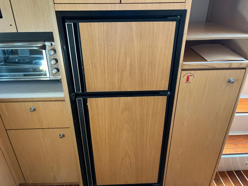 Slide: The Image of 2001 Tiara Yachts 4100 Open interior with wooden cabinetry and built-in appliances. - 32